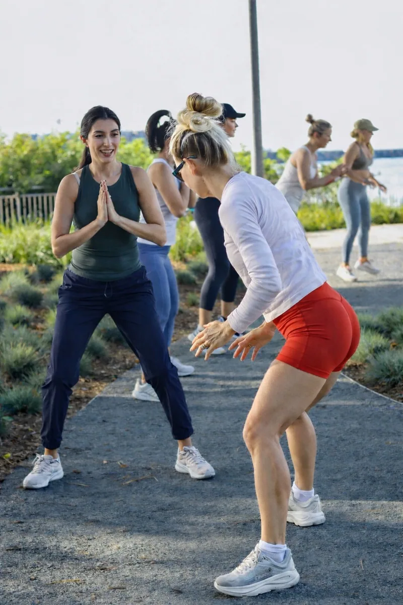 A coach giving personal guidance during a small outdoor class by the water