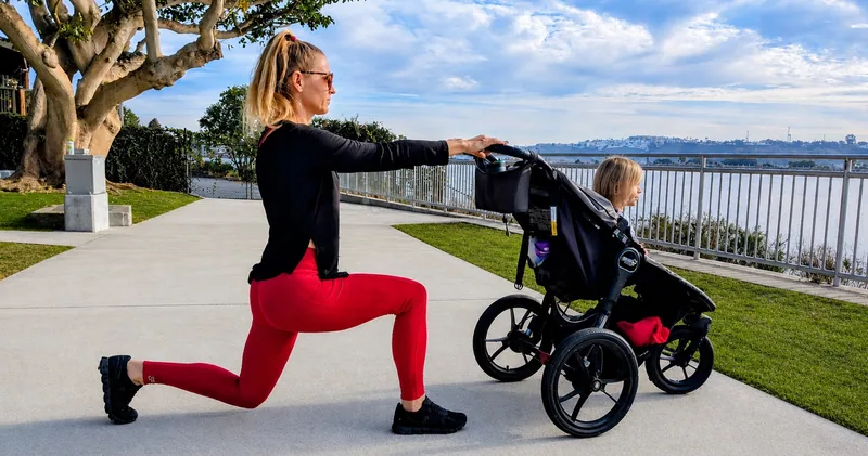 A parent exercising beside a stroller and child at the waterfront